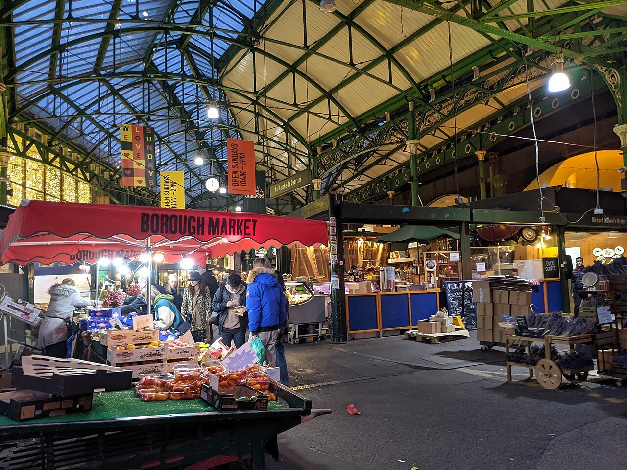 Stalls and shoppers under the green iron and glass roof of Borough Market