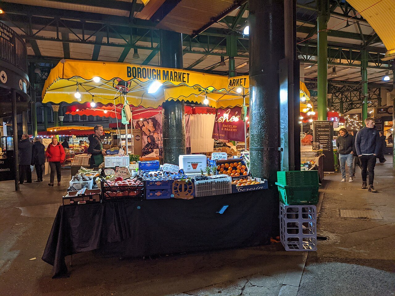 A stall under the market's iron arches, with crates of fruit and vegetables laid out for the day