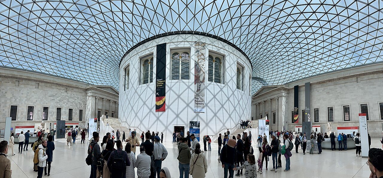 Visitors crossing the Great Court, with the round Reading Room at its center under the glass roof