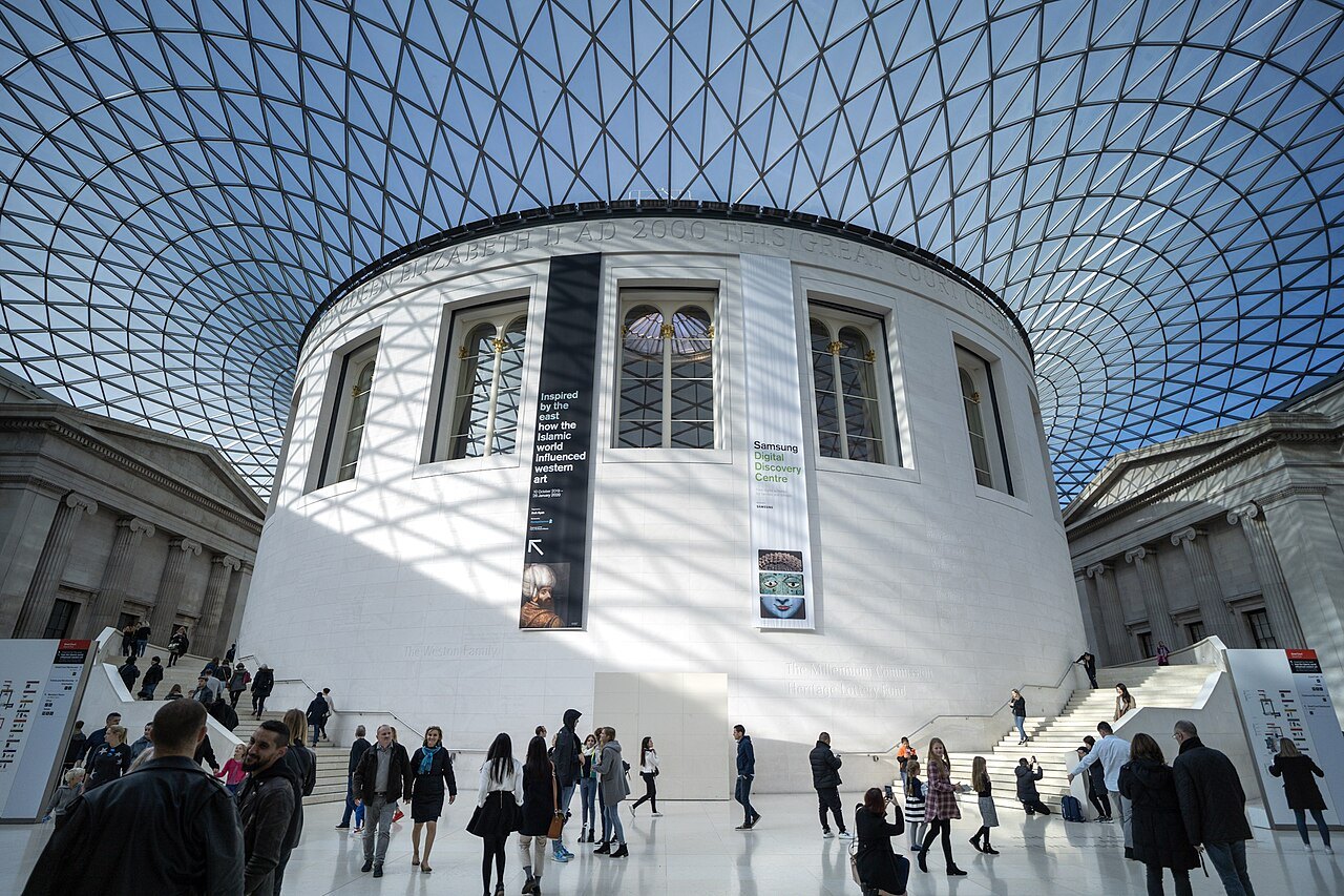 Visitors on the steps around the Reading Room in the Great Court, with sunlight through the roof