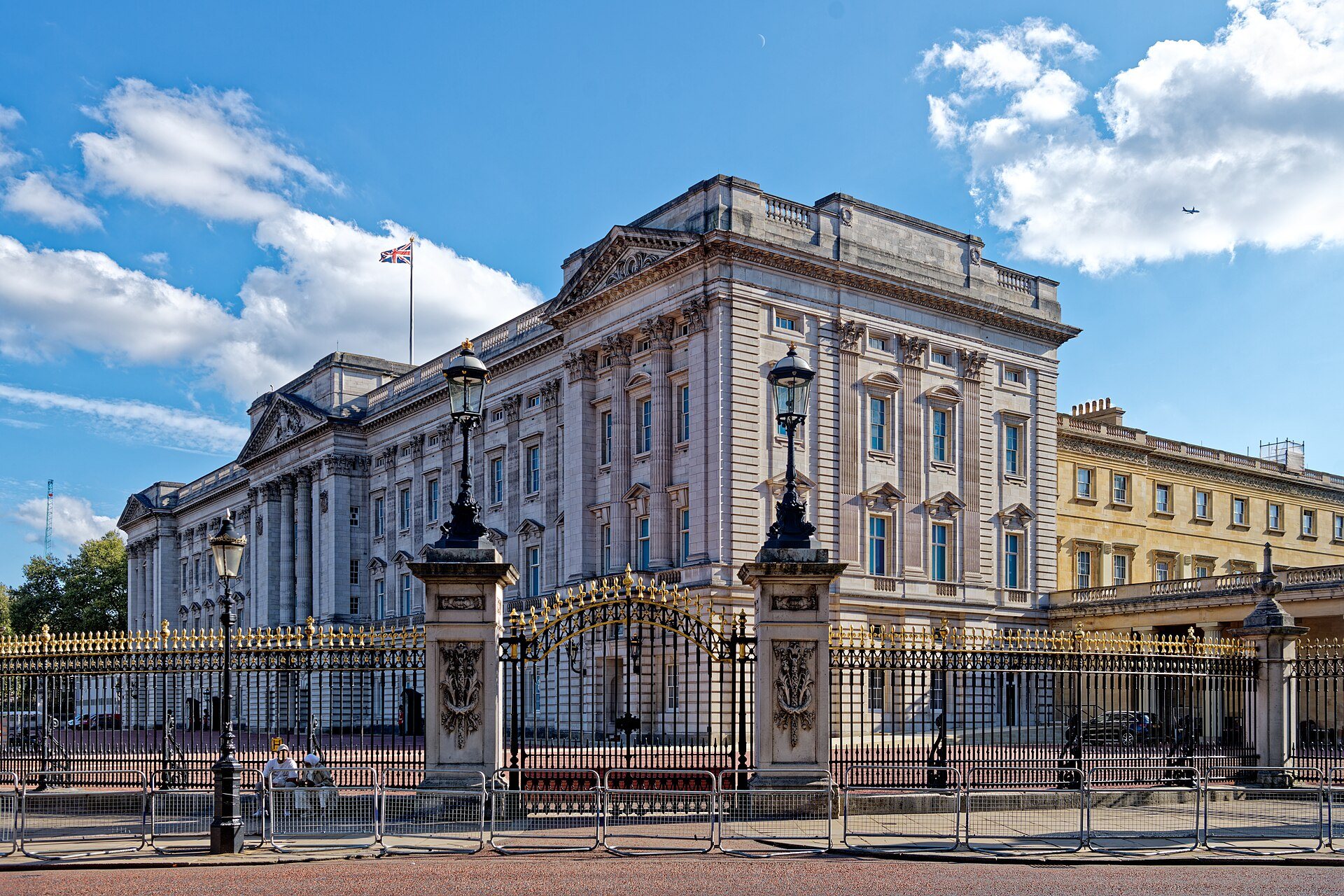 Buckingham Palace behind its gold-topped railings, seen from the north-east on a day of broken cloud