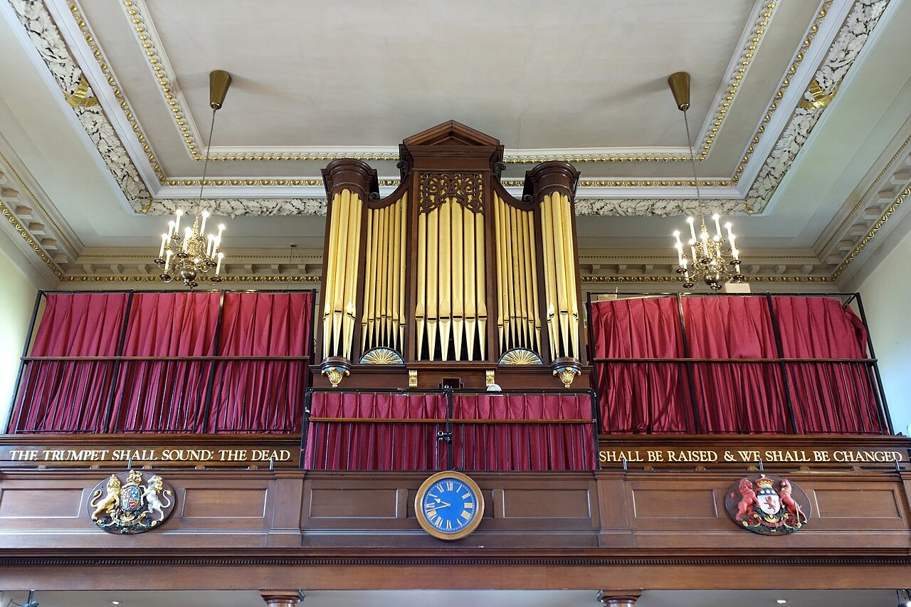 The organ of St Paul's Church, gilded pipes above a gallery front hung with red curtains