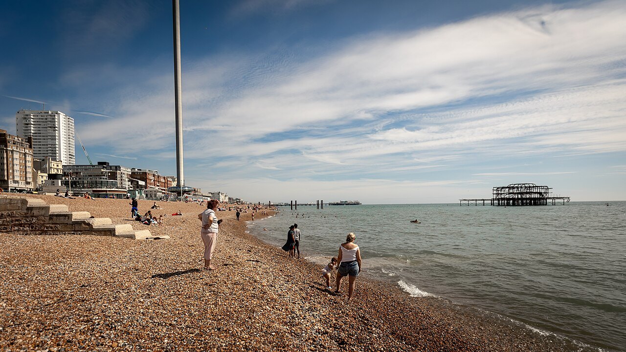 The shingle beach at Brighton, with the remains of a pier standing in the sea