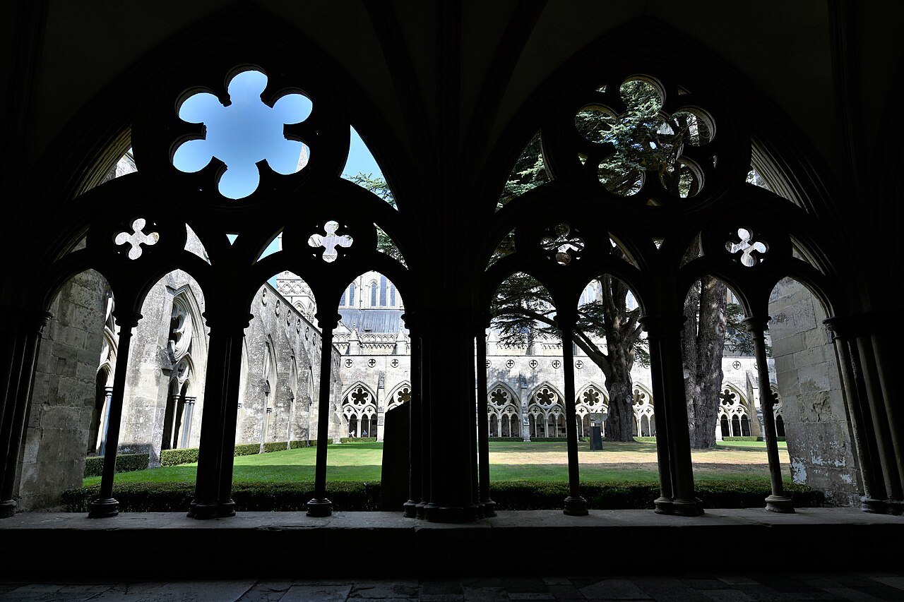 Gothic tracery in the cloister of Salisbury Cathedral, looking through to the green court