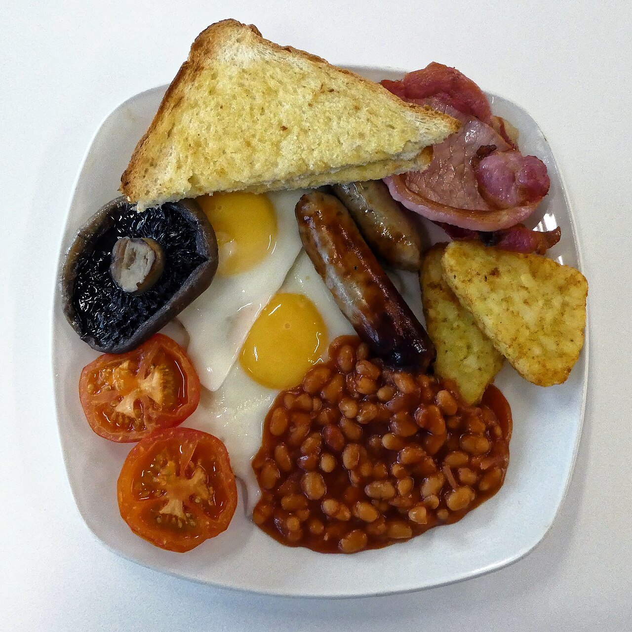 A full English breakfast: eggs, bacon, sausage, mushroom, tomato, beans, hash browns and fried bread