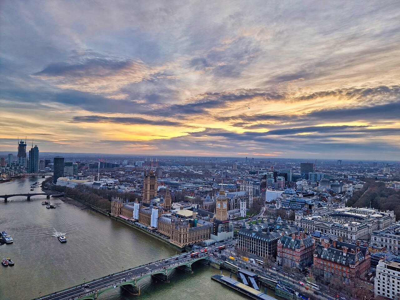 A view over the Thames and Westminster at dusk from a great height, with the bridges below