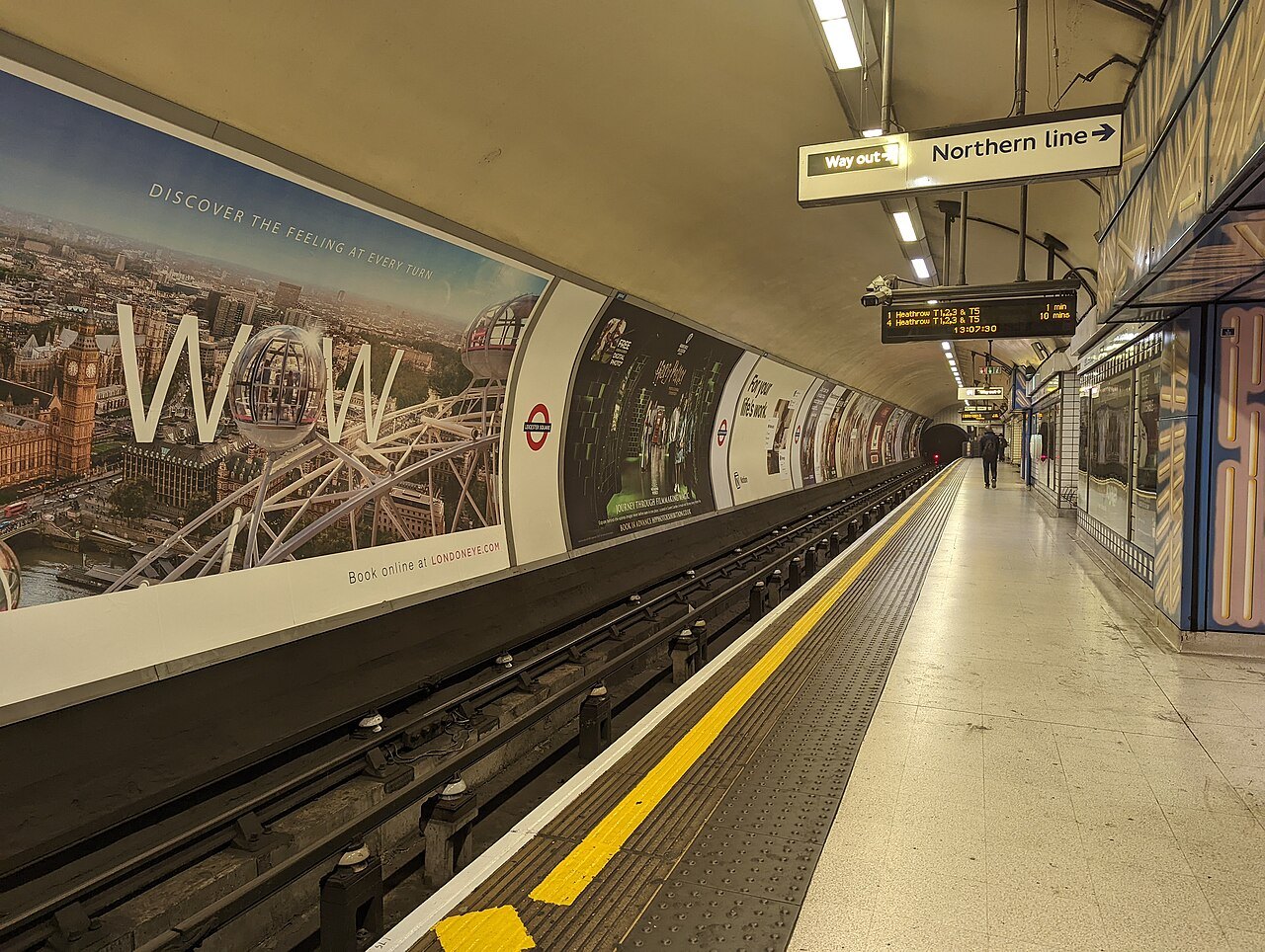 A Northern line platform at Leicester Square, the tiled curve of the tunnel ahead of the yellow edge