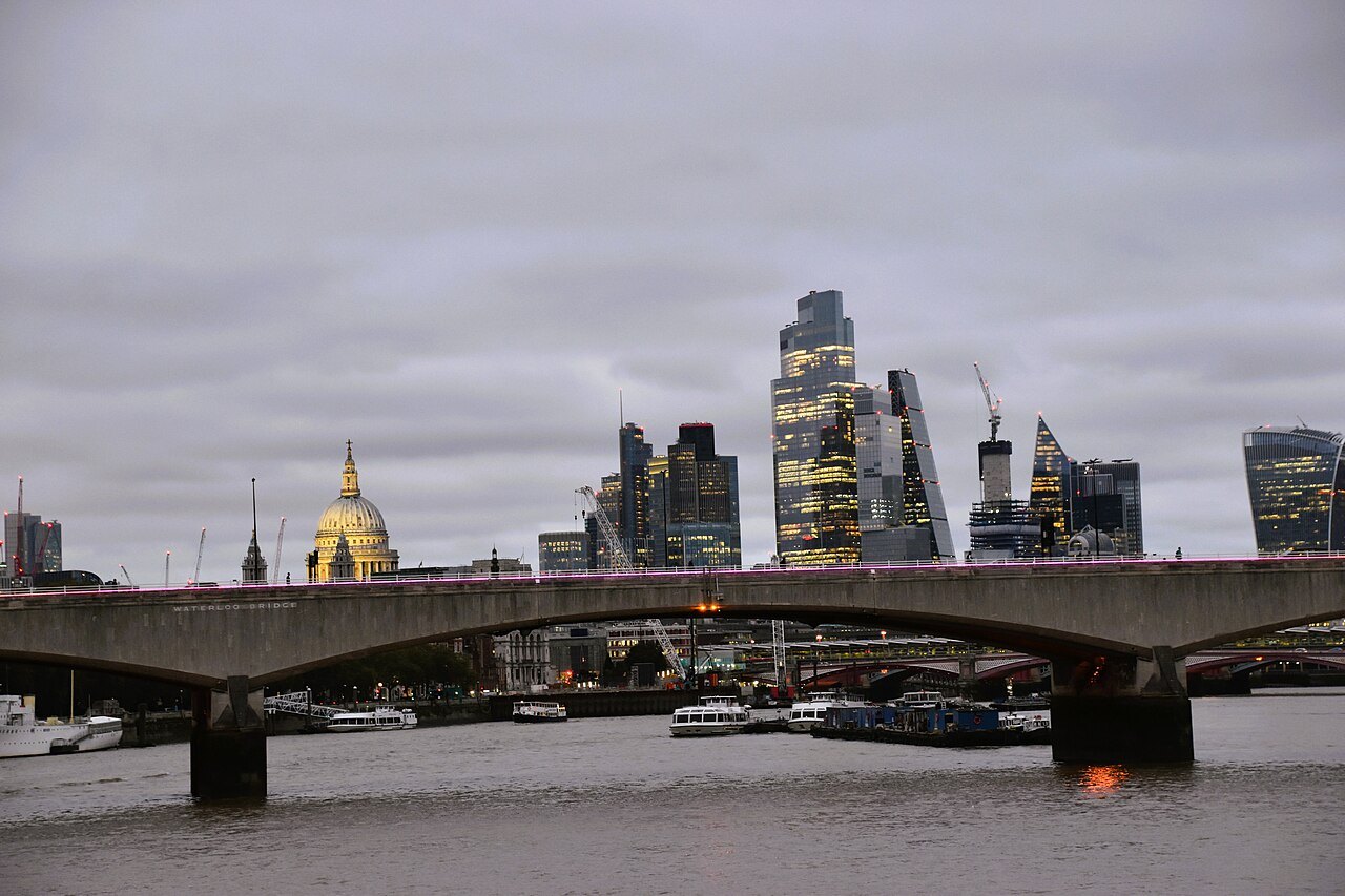 Waterloo Bridge with the dome of St Paul's and the City's towers beyond, under a heavy sky
