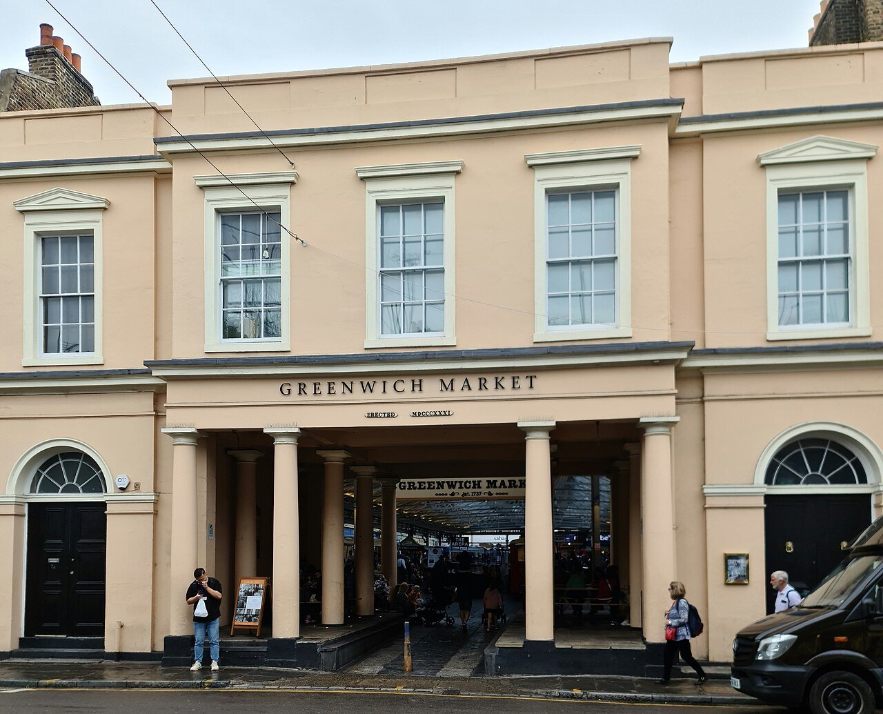 The entrance to Greenwich Market, a pale yellow building with an arched doorway and columns