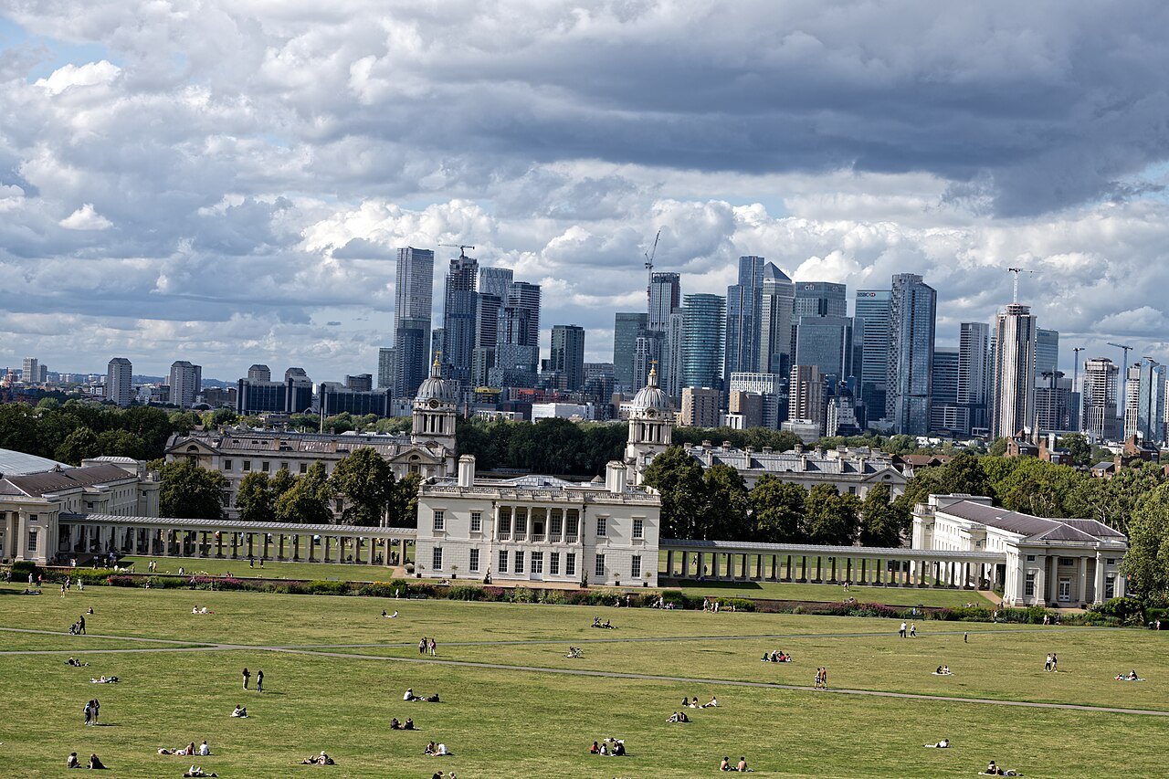 The Queen's House and its colonnades, with the city skyline of Canary Wharf rising behind
