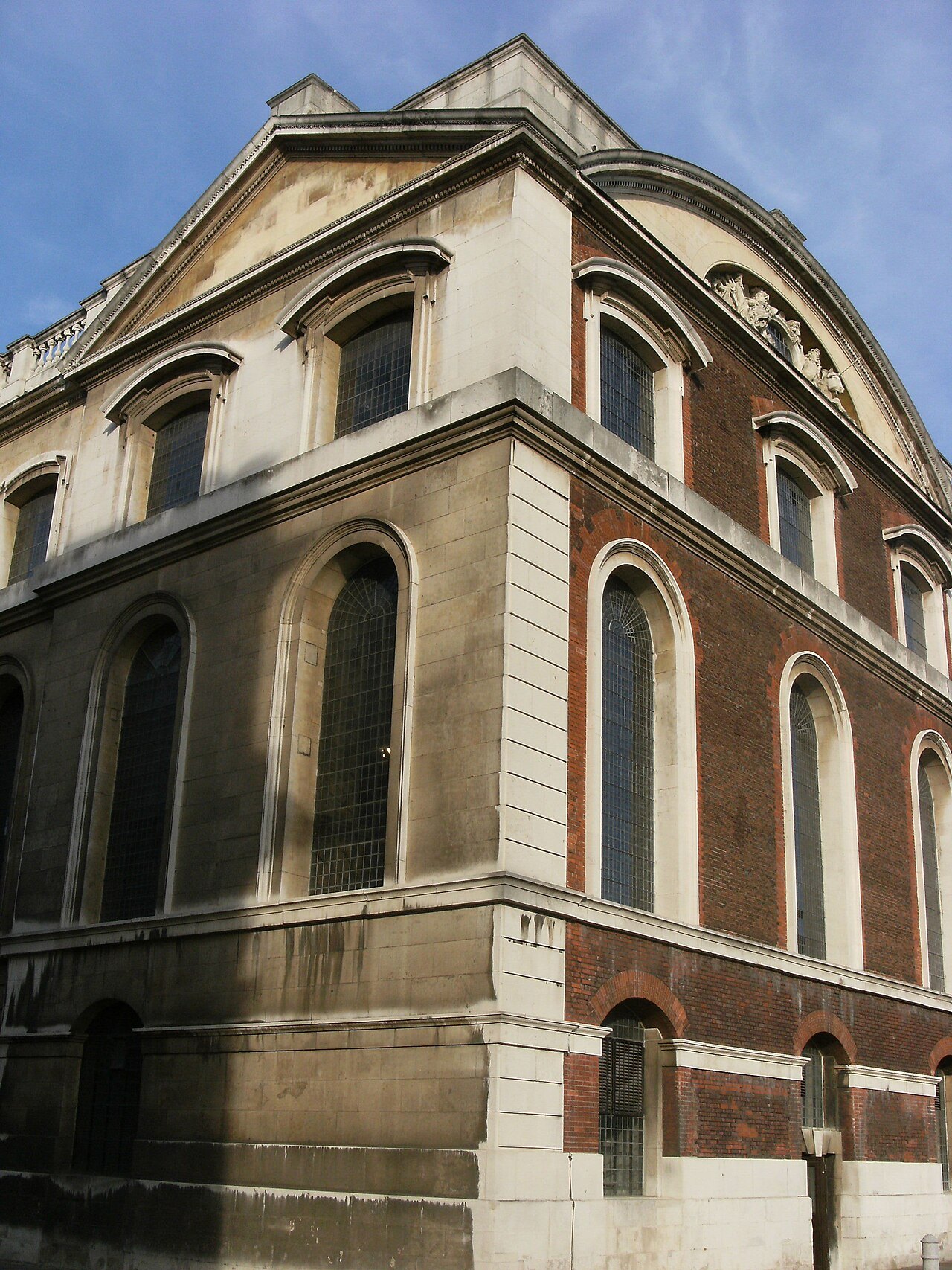 The brick and stone corner of King William Court at the Old Royal Naval College, with tall arched windows