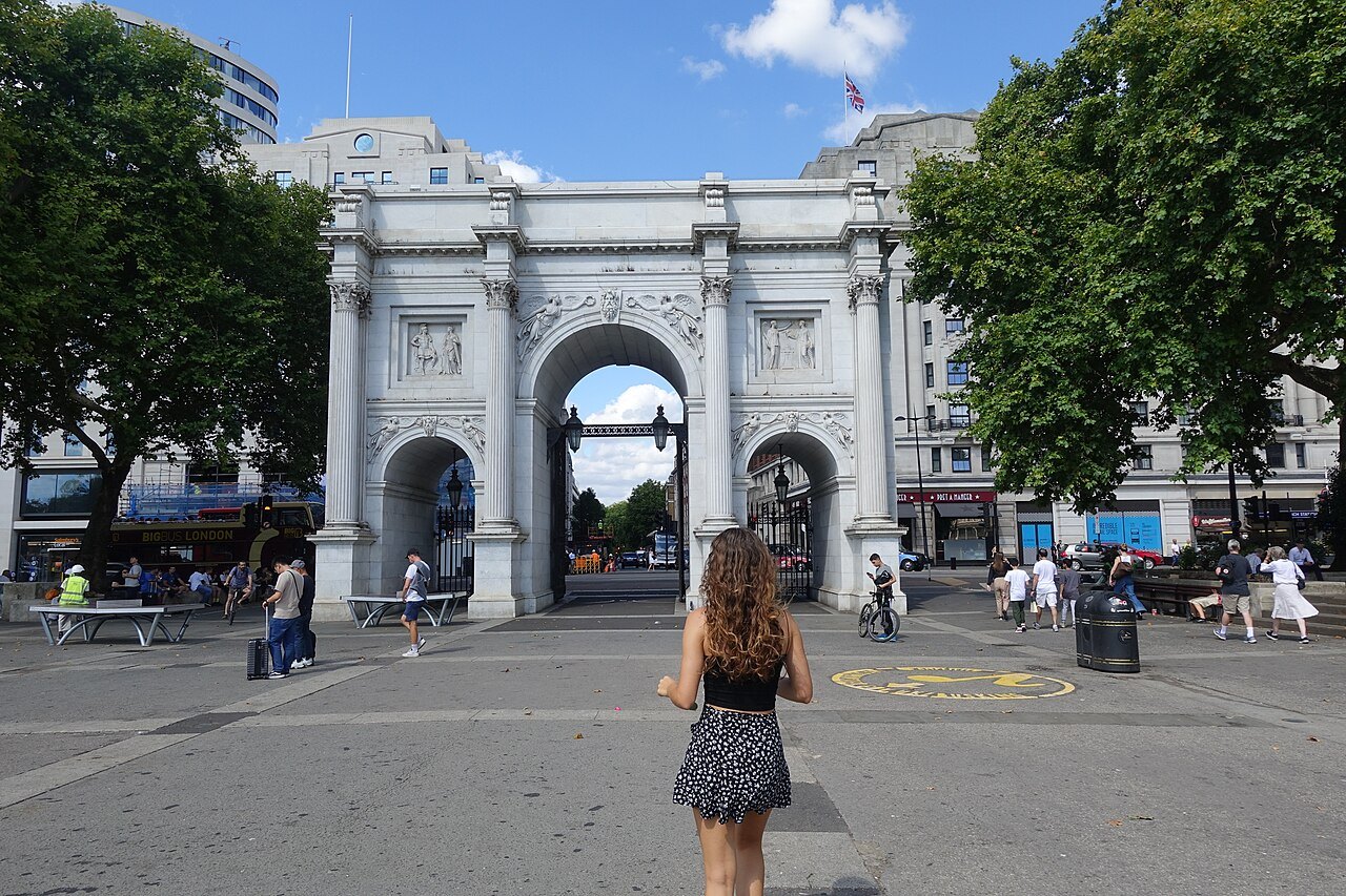 Marble Arch from the pavement across the road, with a visitor looking towards it