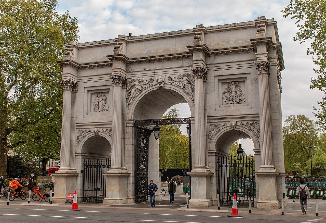 Marble Arch at the corner of Hyde Park, its white stone arches and gates seen from the roadway