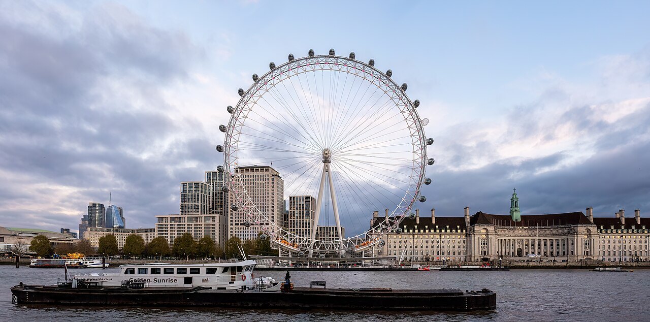 The London Eye and County Hall across the Thames, with a barge on the water