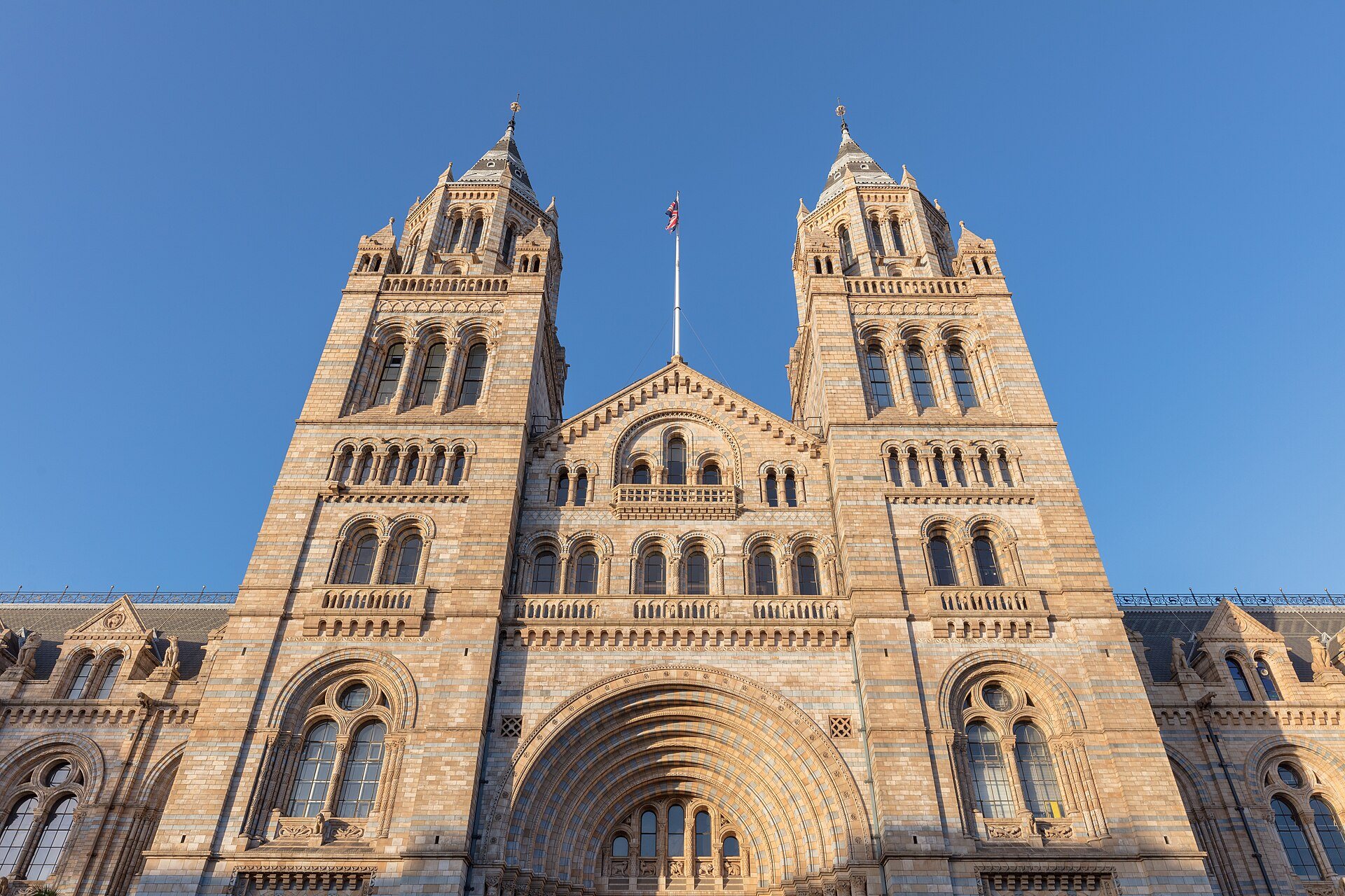The twin towers of the Natural History Museum and its central arch, in warm light