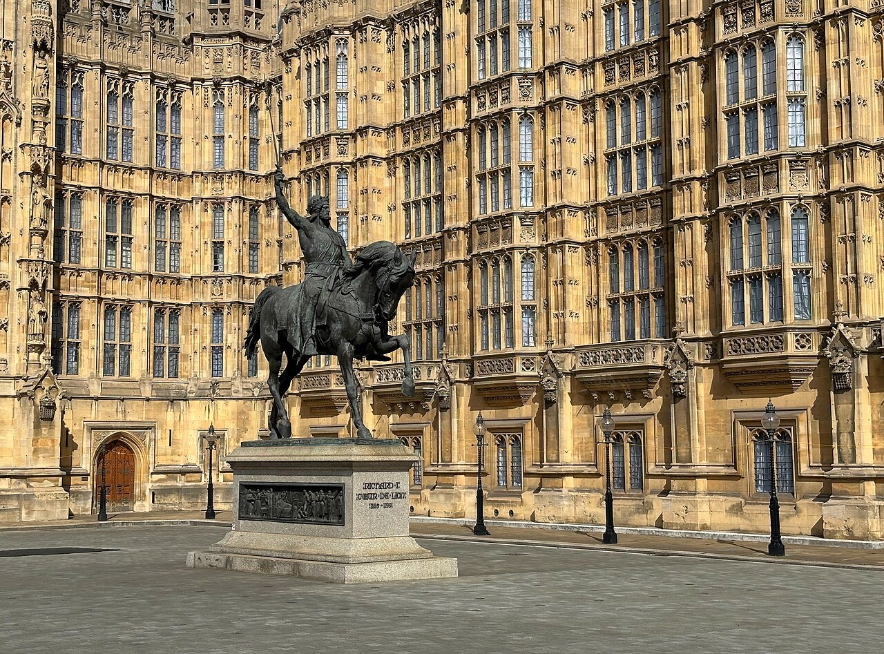 The statue of Richard the Lionheart on its plinth in front of the palace's stone walls