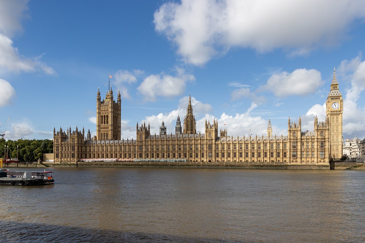 The Houses of Parliament across the water, with the Victoria Tower at the left and the Elizabeth Tower at the right