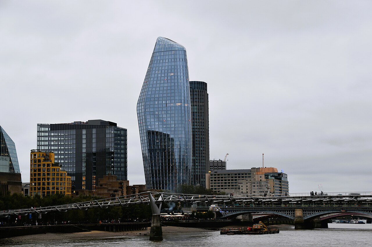 A tall glass tower beside the railway bridge at Blackfriars, seen from the river