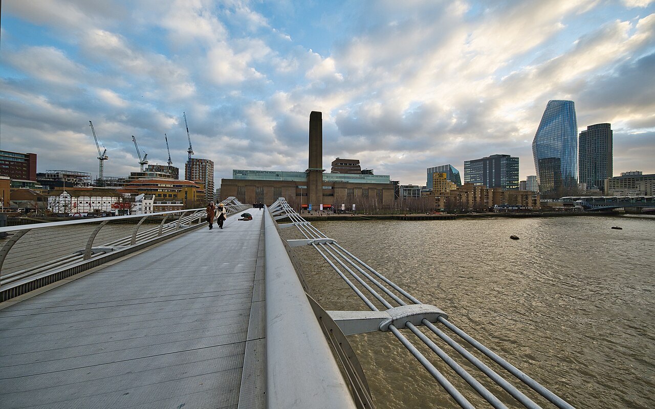 The Millennium Bridge's deck and rail leading to Tate Modern in low evening light