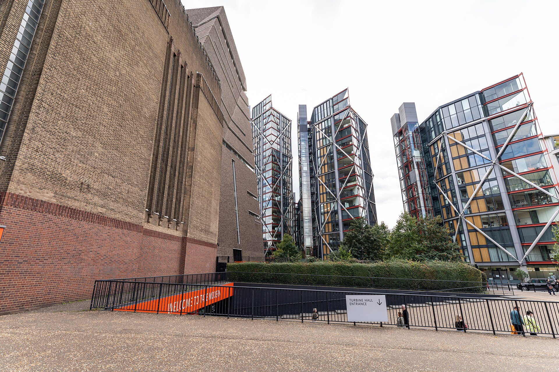The brick wall of Tate Modern, with the steel and glass flats beside it and an orange stair at the foot