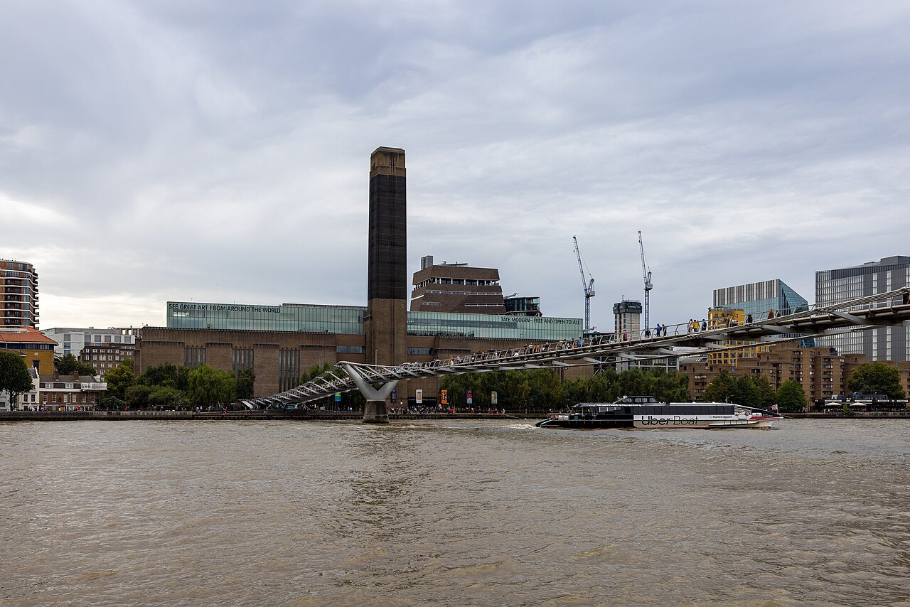 Tate Modern across the Thames, with the Millennium Bridge and cranes behind the river