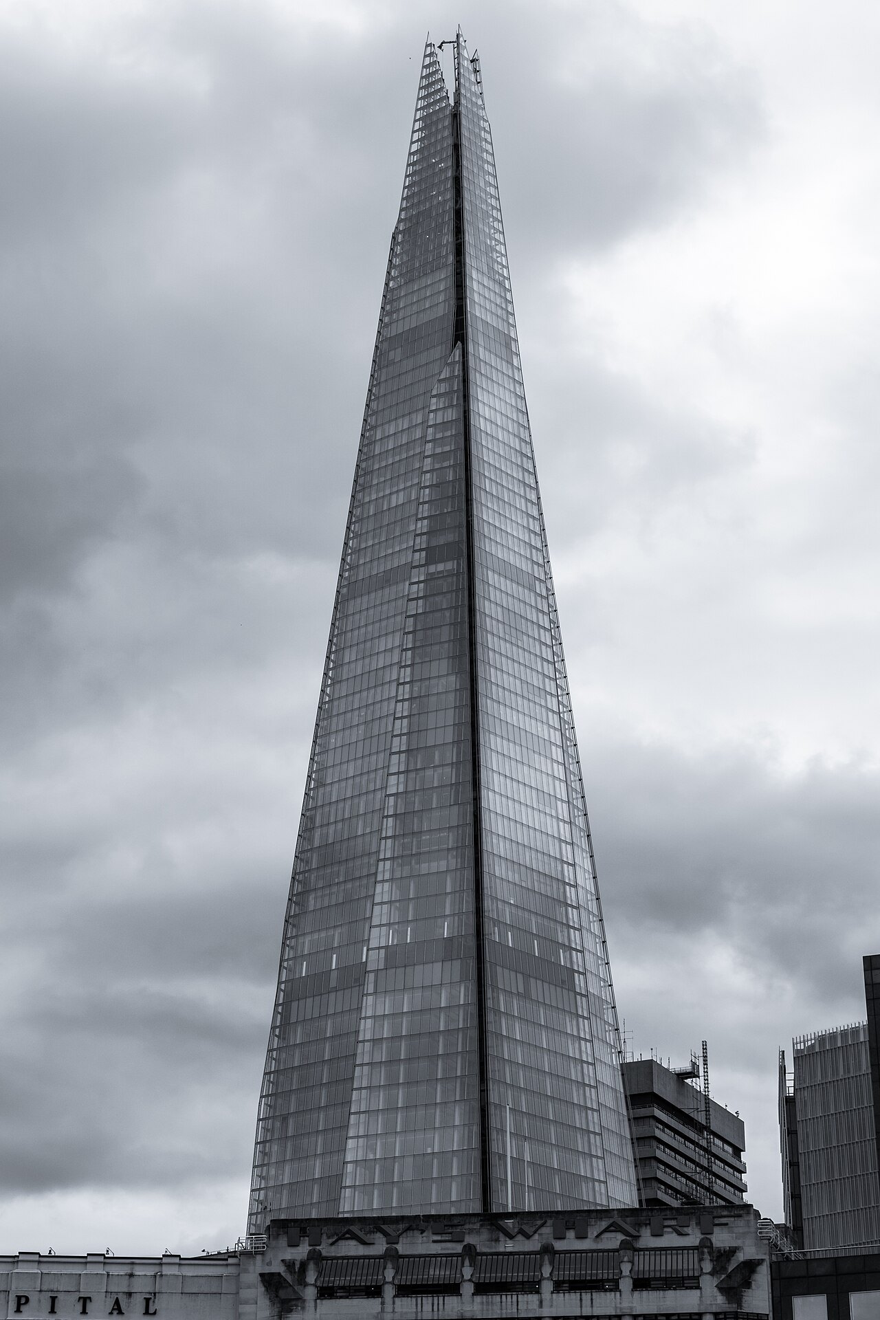 The steep glass spire of the Shard, shot from below against grey cloud