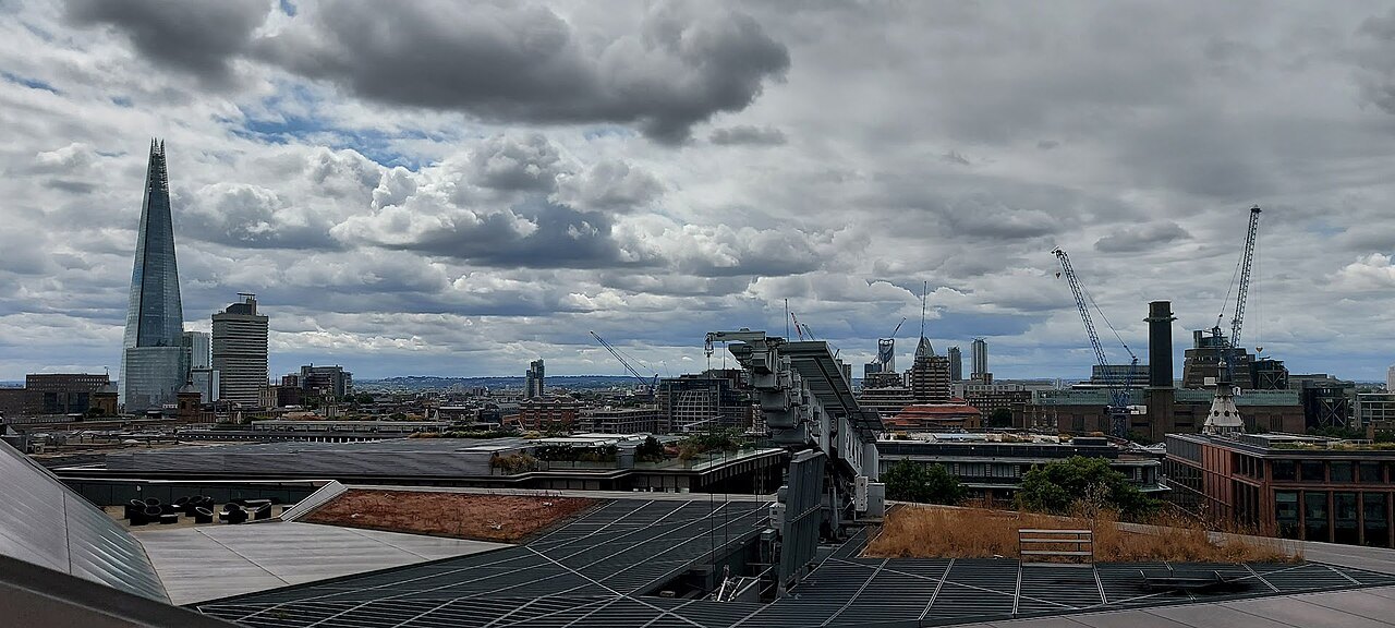 The Shard rising behind the rooftops of the City, seen over a modern roof terrace