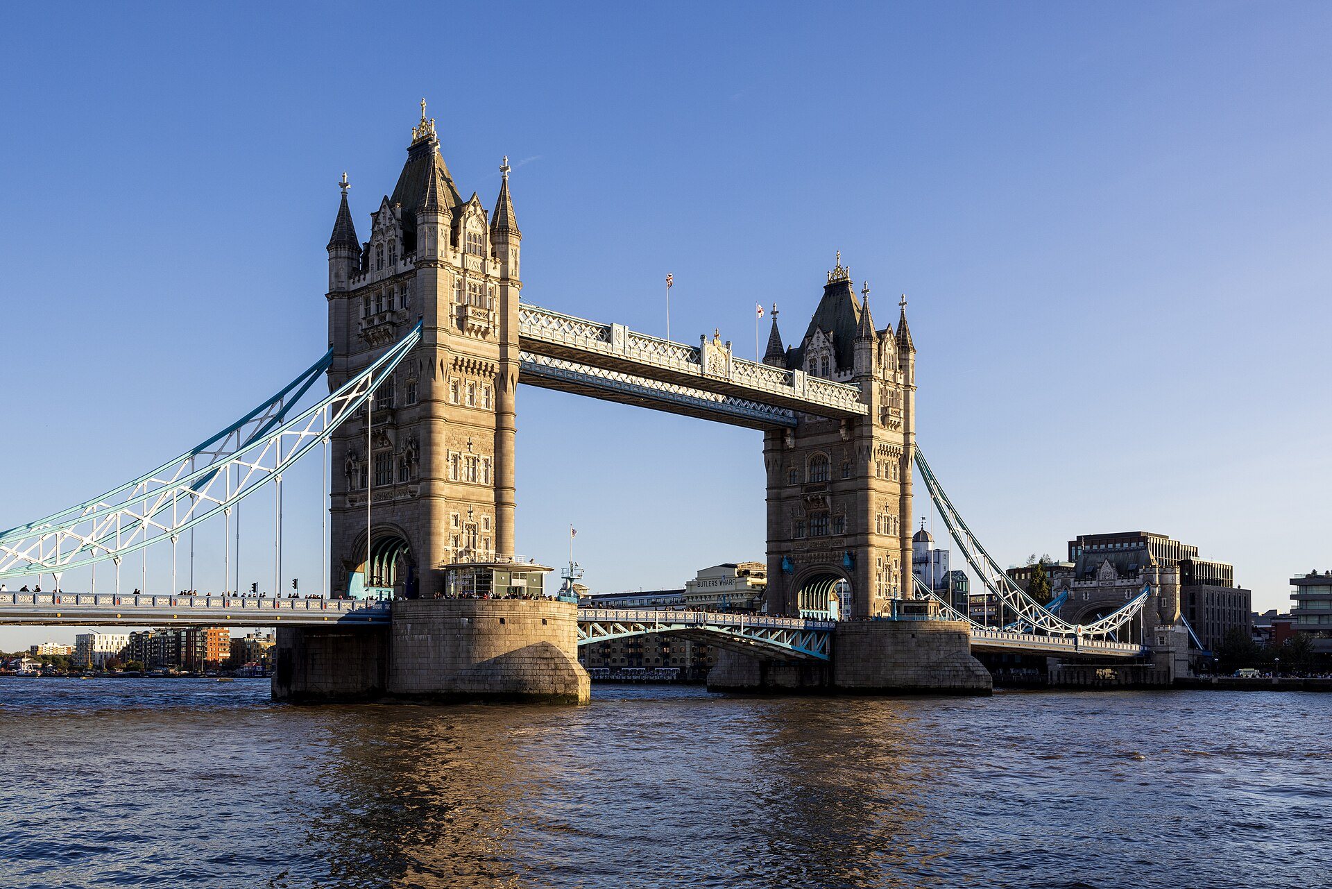 Tower Bridge from Tower Wharf, its towers and walkways against a blue sky