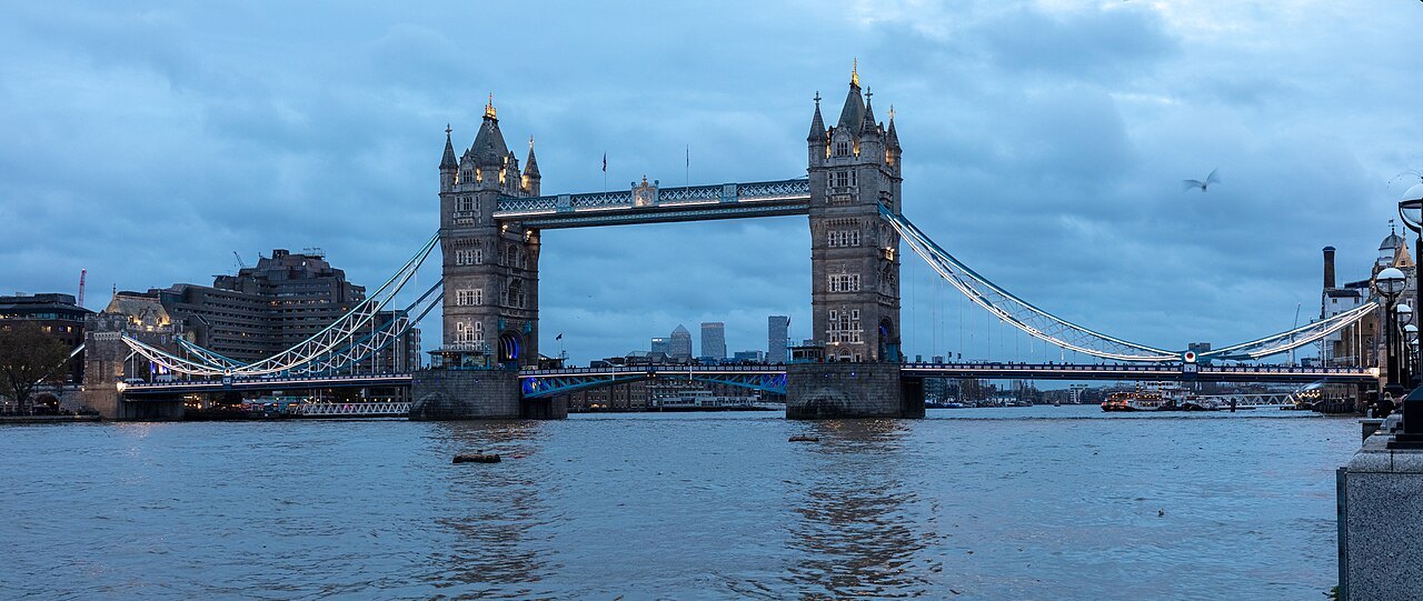 Tower Bridge across a blue evening Thames, its walkways and towers lit by the last of the daylight