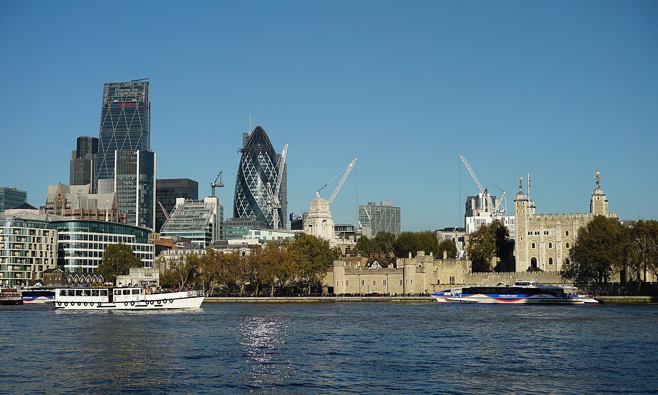 The City's towers and the Tower of London across the river, with a tour boat passing