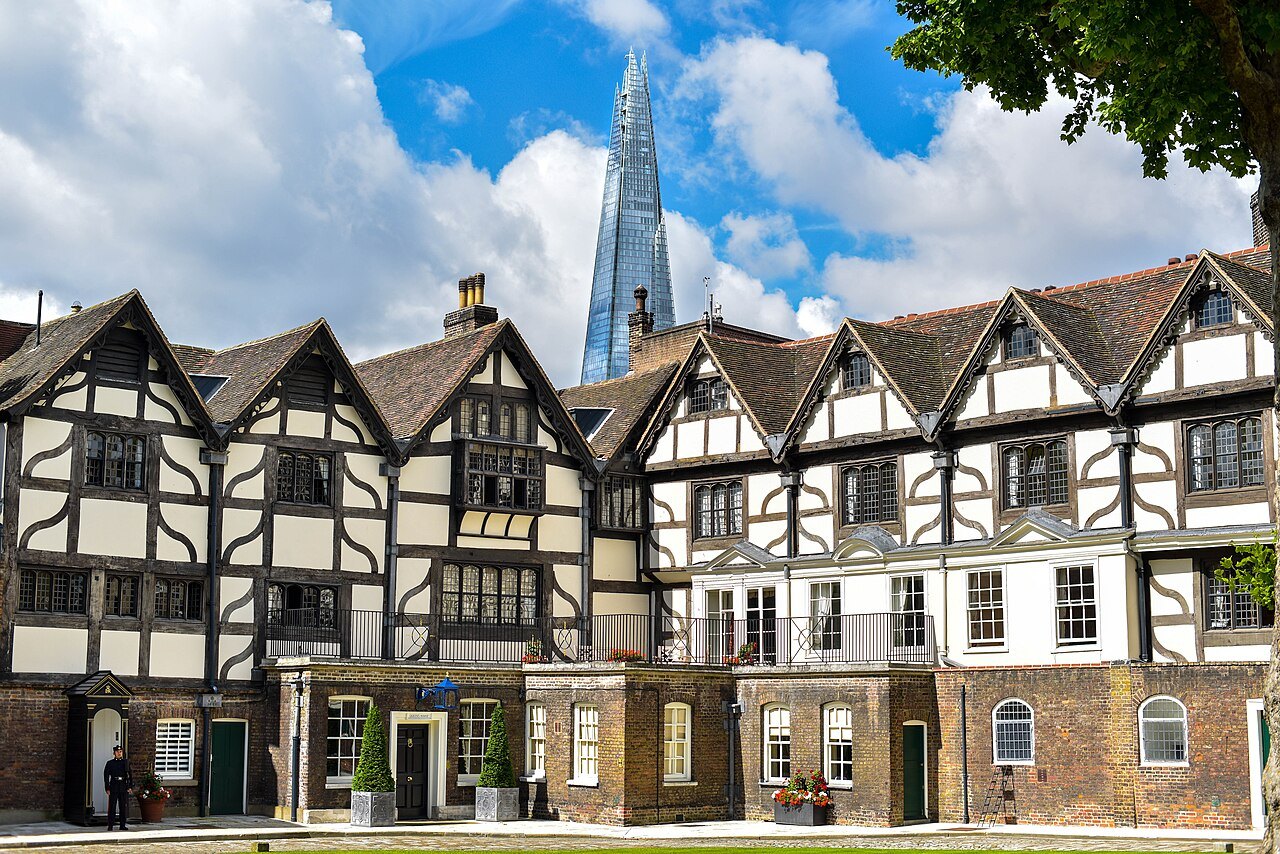 The timber-framed Queen's House at the Tower of London, with the Shard rising behind its roofs