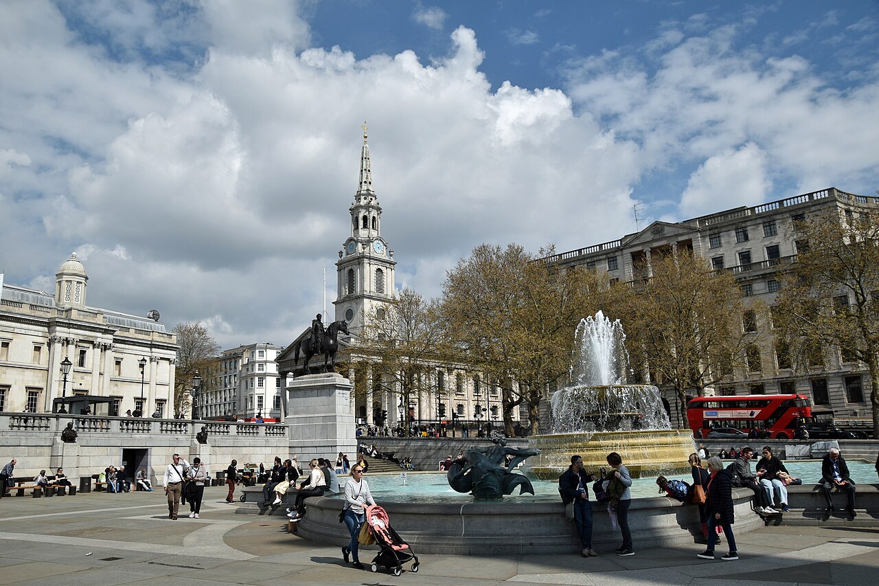 Trafalgar Square on a bright day, with the fountains, St Martin-in-the-Fields and a double-decker bus