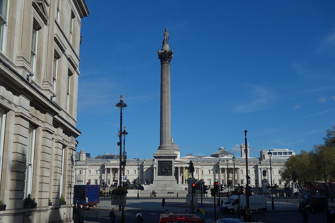 Nelson's Column and the square beyond a street corner, with the National Gallery's front across the road