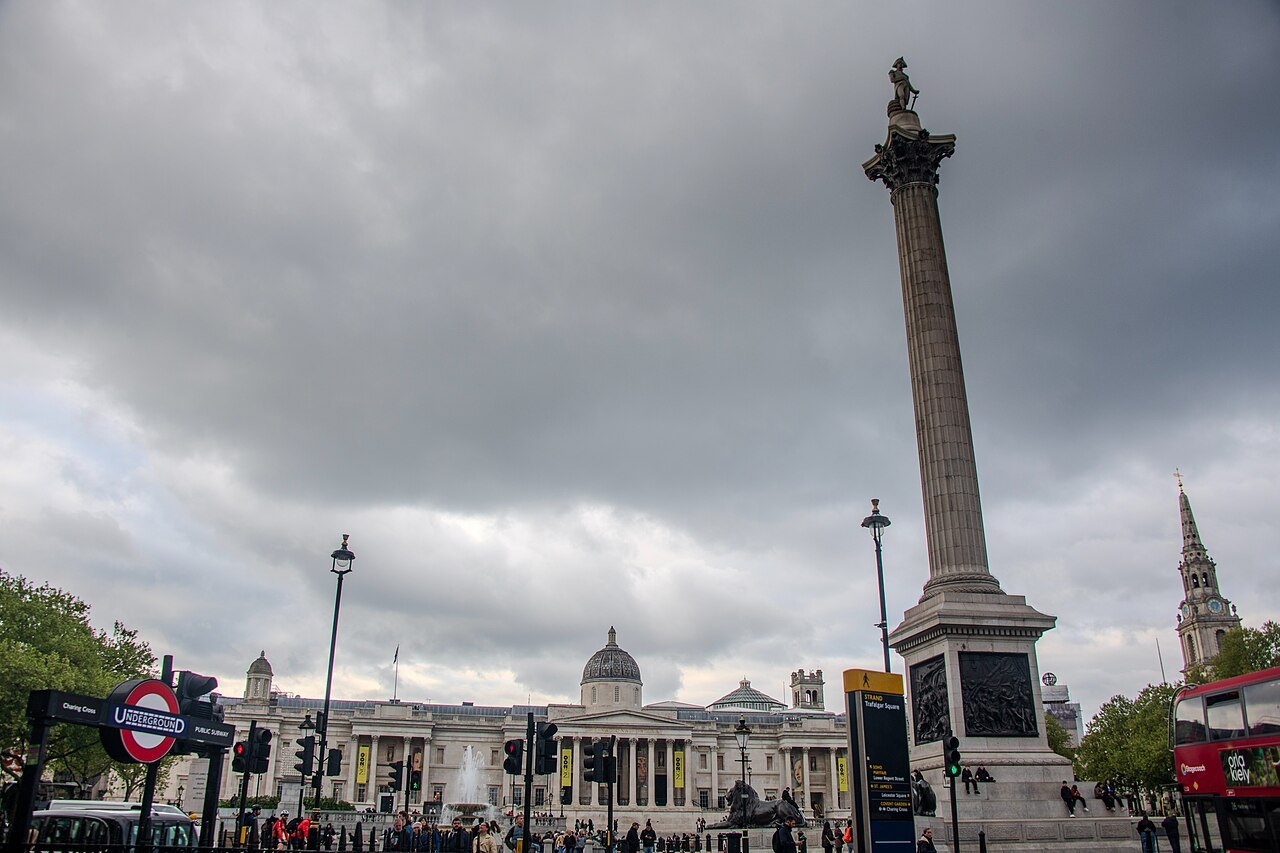 Nelson's Column under a grey sky, with the National Gallery behind and an Underground sign below