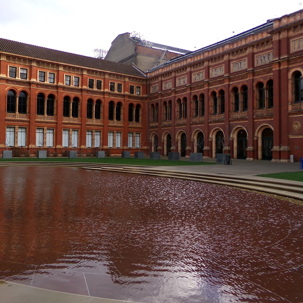 A cloister of red brick arches round the pool in the John Madejski Garden at the V&A