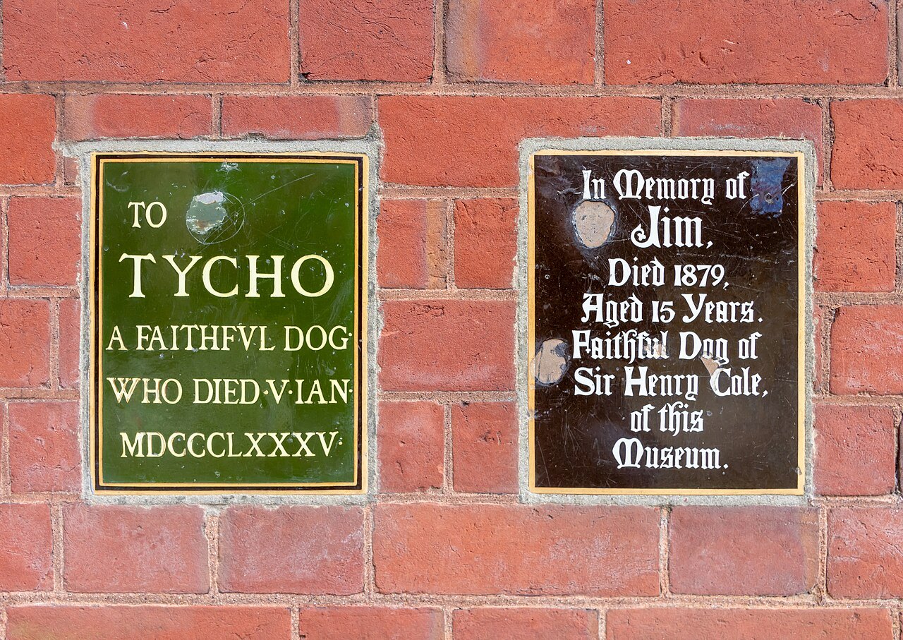 Two small plaques set in red brick on the museum's wall, one to a faithful dog named Tycho and one to a dog called Jim