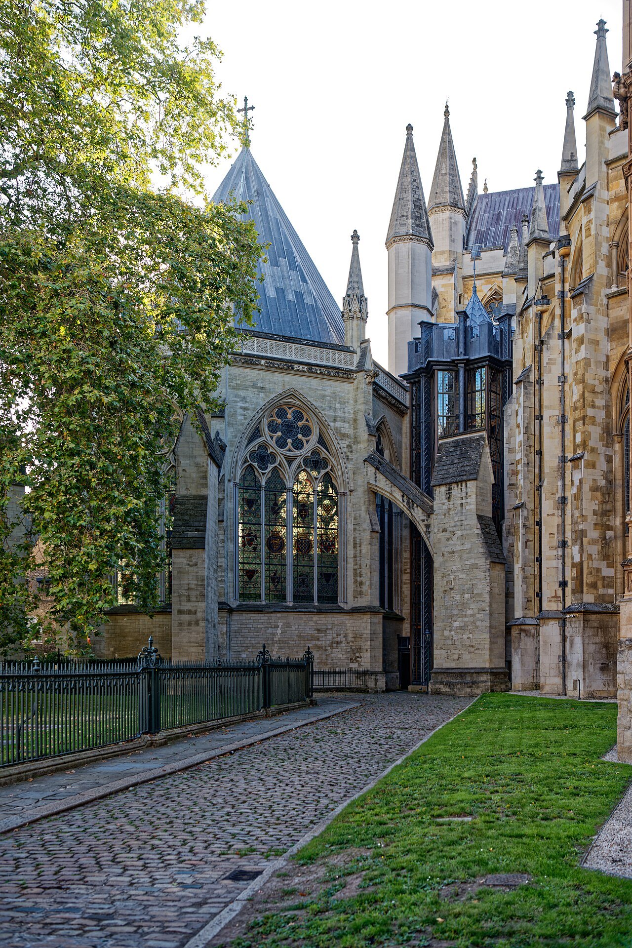 The chapter house and a flagstone path beside the abbey, with a bright lawn at the left