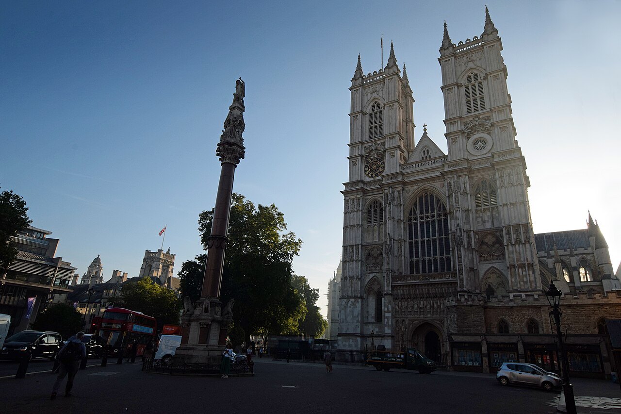 Westminster Abbey seen across the road, a stone column at the left and the west towers behind